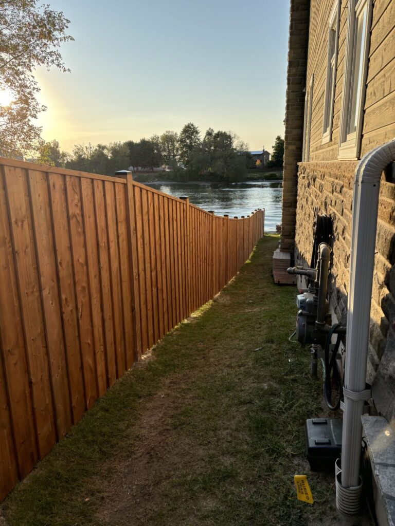 Wood fence under construction in Barrie, Ontario with posts and panels being installed by Post Holes Plus.