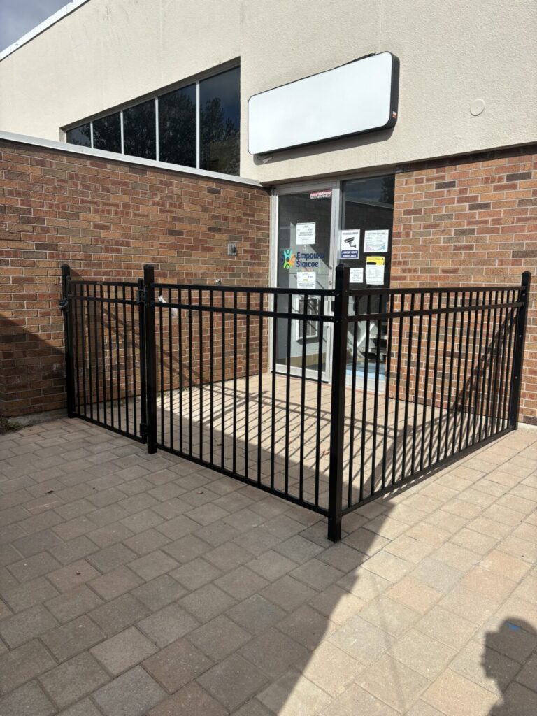 Wood fence being constructed in Bradford, Ontario by the Post Holes Plus team using drilled posts and level panels.