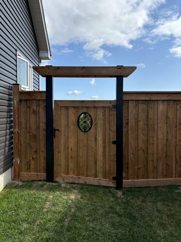 Fence under construction in New Tecumseth with wooden posts and panels installed by Post Holes Plus.