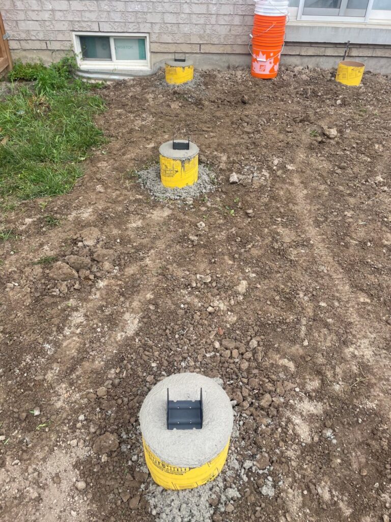 Concrete footings being installed in a Bradford backyard to support a wooden gazebo by Post Holes Plus.
