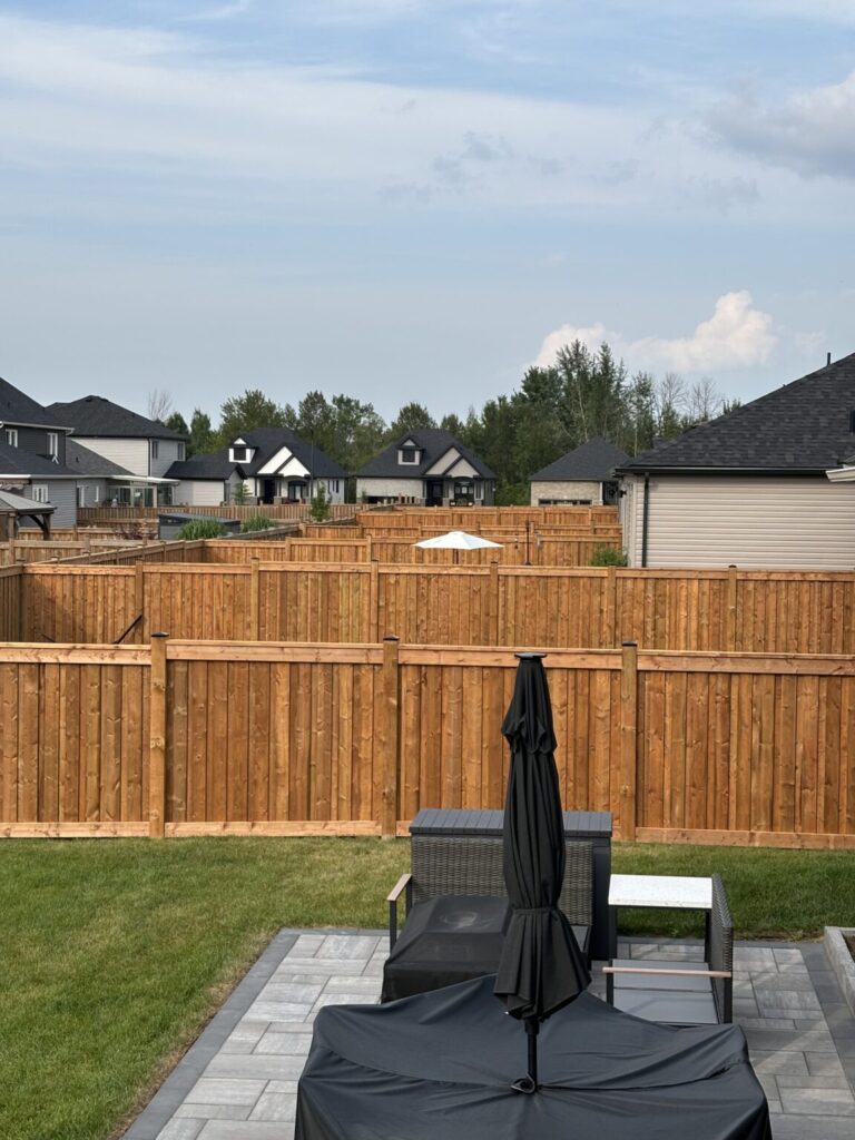 Fence construction in progress in Innisfil, Ontario with wooden posts and panels being installed by Post Holes Plus.