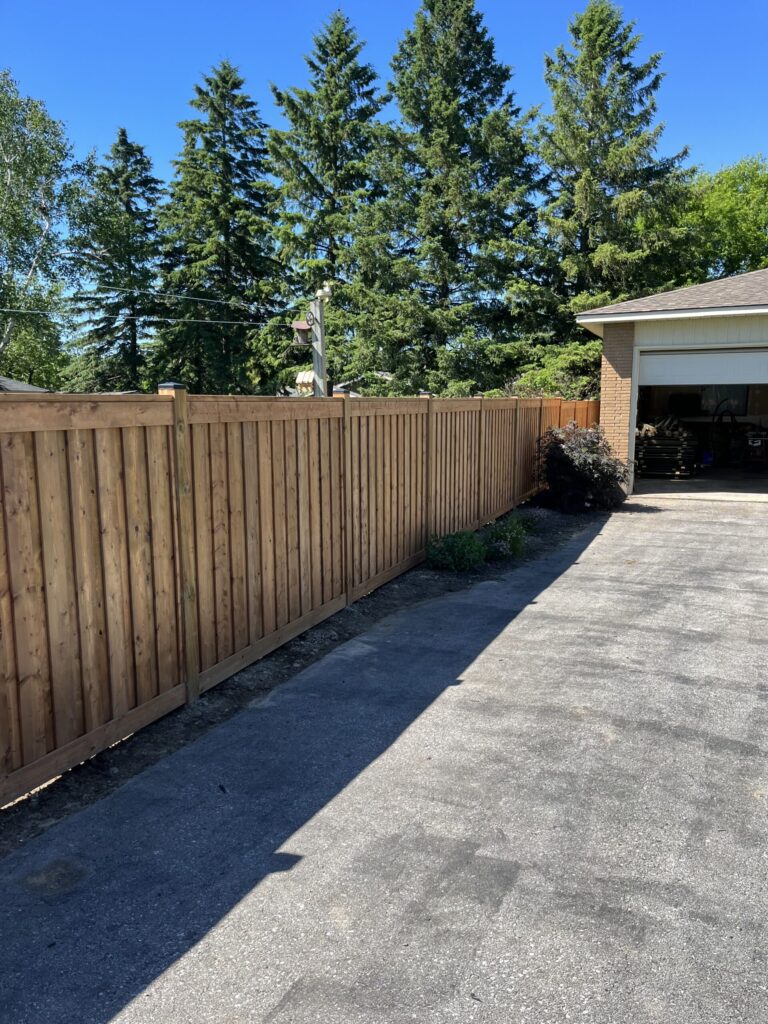 Fence being constructed with concrete-set posts by Post Holes Plus in a residential yard in Barrie, Ontario.