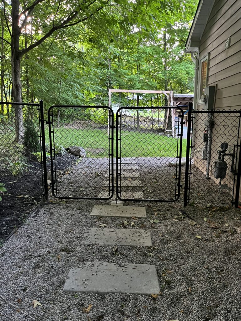 Post Holes Plus crew constructing a wooden fence with concrete-set posts in New Tecumseth.