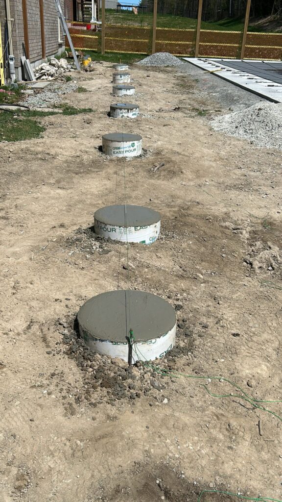 Concrete shed footings being installed by Post Holes Plus in a New Tecumseth backyard.